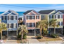 Aerial view of three colorful beach houses with ocean views at 2022 N Waccamaw Dr., Garden City Beach, SC 29576