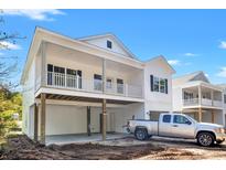 Charming elevated beach home with white siding, spacious covered parking and a quaint porch at 2428 Park St., North Myrtle Beach, SC 29582