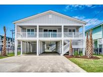 Charming beach house with elevated design, white columns, and well-manicured landscaping at 301 43Rd Ave. N, North Myrtle Beach, SC 29582
