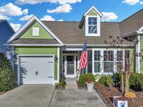 Charming green house with American flag and well-maintained landscaping at 316 Saint Catherine Bay Ct. # 316, Myrtle Beach, SC 29575