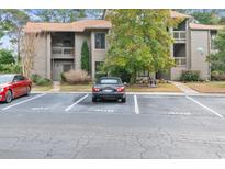 View of the building's exterior with parking, landscaping, and a well-maintained facade and car parked in parking space at 401 Indian Wells Ct. # 401, Murrells Inlet, SC 29576