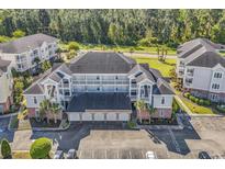 Aerial view of condo building with parking and landscaping at 4870 Dahlia Ct. # 19-103, Myrtle Beach, SC 29577