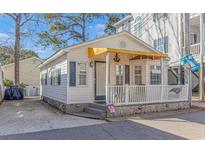 Charming cottage with yellow awning, white siding, and stone accents at 6001-Z34 S Kings Hwy., Myrtle Beach, SC 29575