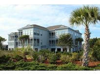 Attractive three-story building with lush landscaping at 11 Inlet Point Dr., Pawleys Island, SC 29585