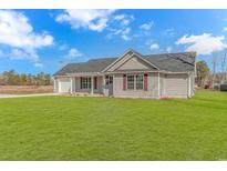 Newly built home with gray siding, a large yard, and a spacious driveway at 1282 Scenic Dr., Loris, SC 29569