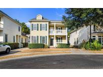 Two-story house with light beige siding, dark shutters, and a front porch at 171 Beaufain Ct., Pawleys Island, SC 29585