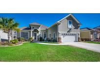 Charming home featuring lush green lawn, manicured landscaping, and a two-car garage at 2004 Via Palma Dr., North Myrtle Beach, SC 29582