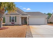 Tan house with green shutters, a two-car garage, and a landscaped yard at 329 Hillsborough Dr., Conway, SC 29526