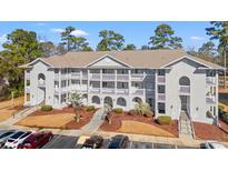 Two-story condo building with gray siding, balconies, and ample parking at 4416 Eastport Blvd. # N15, Little River, SC 29566