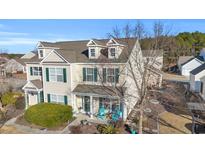 Two-story tan house with green shutters, front porch, and landscaping at 805 Barn Owl Ct. # 805, Myrtle Beach, SC 29579