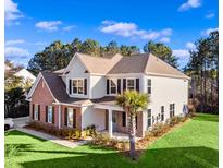 Beautiful two-story home featuring a well-manicured lawn, brick accents, shutters and a neatly kept garden at 1303 Bermuda Grass Dr., Myrtle Beach, SC 29579