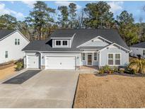 Two-story house with gray siding, three-car garage, and landscaped yard at 146 Caroline Ct., Murrells Inlet, SC 29576