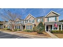 Two-story townhome with brick and siding exterior, landscaping, and American flag at 155 Chenoa Dr. # E, Murrells Inlet, SC 29576