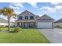 Two-story house with gray siding, brick accents, and a landscaped yard at 323 Camrose Way, Myrtle Beach, SC 29588
