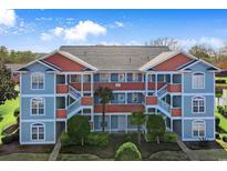 Two-story building with blue and orange exterior, featuring staircases and landscaping at 4641 Lightkeepers Way # 3A, Little River, SC 29566