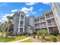 Three-story building with brick and pastel-colored siding, landscaping, and walkway at 4729 Wild Iris Dr. # 102, Myrtle Beach, SC 29577