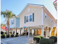 Charming elevated home features a spacious covered area, stairs, landscaping, and a welcoming atmosphere at 502 Castellar Ln., Little River, SC 29566