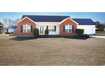 Brick ranch house with attached garage and a spacious lawn at 5705 Cates Bay Hwy., Conway, SC 29527