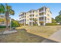 Three-story building with yellow siding, balconies, and ample parking at 601 Hillside Dr. N # 1506, North Myrtle Beach, SC 29582