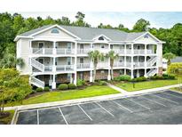 Three-story building with multiple units, ample parking, and landscaping at 6015 Catalina Dr. # 431, North Myrtle Beach, SC 29582