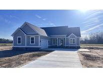 Newly constructed home with gray siding, gray roof and a concrete driveway at 604 Highway 747, Loris, SC 29569