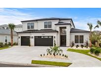 Two-story house with a three-car garage, stone accents, and landscaping at 215 82Nd Ave. N, Myrtle Beach, SC 29572