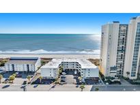 Aerial view of beachfront property showing building, parking, and ocean at 3701 S Ocean Blvd. # 109, North Myrtle Beach, SC 29582