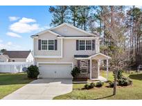 Charming two-story home featuring a single-car garage, landscaped yard, and inviting covered porch at 413 Cotton Grass Dr., Loris, SC 29569