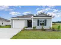 Newly constructed light grey house with a white garage door and green lawn at 4131 Robin Song Way, Loris, SC 29569