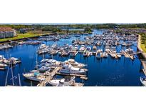 Aerial view of a marina with numerous boats docked in the harbor and condos along the waterfront at 4609 Lightkeepers Way # 11J, Little River, SC 29566
