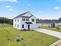 Two-story house with white siding, two-car garage, and landscaping at 56 Cape Point Dr., Conway, SC 29527