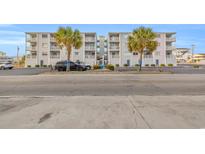 Two-story building with parking and palm trees in front at 5709 N Ocean Blvd. # 303, North Myrtle Beach, SC 29582