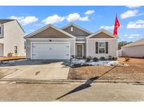 Newly built home with a two-car garage and well-manicured lawn at 589 Talisman Trail, Longs, SC 29568