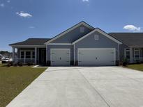 Charming home featuring a two-car garage and a welcoming covered porch at 718 Isle Verde Dr, Myrtle Beach, SC 29579