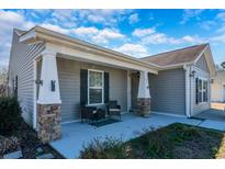 Inviting home featuring a cozy front porch, stylish columns, and tasteful decor with chairs at 801 Benchmade Rd., Conway, SC 29527