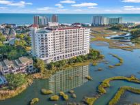Luxury condo building overlooks scenic marshland, ocean, and beachfront cityscape at 9547 Edgerton Dr. # 606, Myrtle Beach, SC 29572