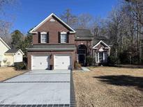 Brick two-story house with a two-car garage and landscaped lawn at 1417 Lanterns Rest Rd., Myrtle Beach, SC 29579