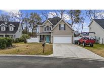 Two-story house with a teal door, white garage door, and a red truck parked in the driveway at 237 Chesapeake Ln., Murrells Inlet, SC 29576