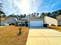 Charming single-story home with well-manicured lawn and two-car garage at 344 Tall Palms Way, Little River, SC 29566