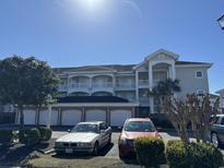 Exterior view of a condo building with parking and landscaping at 4860 Carnation Circle # 304, Myrtle Beach, SC 29579