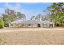 Brick home with landscaped yard and a circular driveway at 5816 Woodside Ave., Myrtle Beach, SC 29577