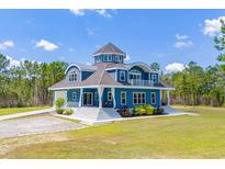 Stunning exterior of blue home with unique architectural design, white trim, and a spacious front yard at 899 Kinlaw Ln., Conway, SC 29527