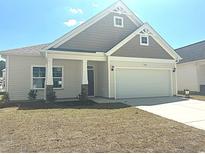 Charming one-story home featuring a two-car garage and a well-manicured front lawn on a sunny day at 1208 Nw Calabash Station Blvd., Calabash, NC 28467
