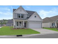 Charming two-story home with gray siding, a well-manicured lawn, and an attached two-car garage at 1212 Nw Calabash Station Blvd., Calabash, NC 28467