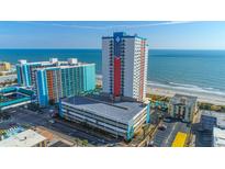 Aerial view of oceanfront high-rise building with parking and surrounding buildings at 1605 S Ocean Blvd. # 1113, Myrtle Beach, SC 29577