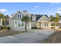 Charming home featuring a well-manicured lawn, mature landscaping, and inviting front porch at 2113 Clematis Ct., Myrtle Beach, SC 29579
