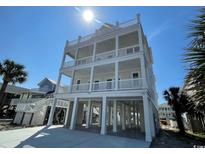 Coastal home with a multi-tiered covered porch offering ocean views and ample outdoor space at 229 South Waccamaw Dr., Garden City Beach, SC 29576