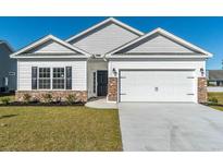 Newly constructed home with a brick and siding exterior, two-car garage, and manicured lawn at 403 Lifestyle Court, Surfside Beach, SC 29575