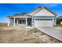 Newly constructed home with gray siding, stone accents, and a two-car garage at 4983 Dupont Rd., Conway, SC 29526