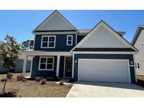 Charming two-story home with blue siding, a white garage door, and manicured landscaping at 566 Haven View Way, Murrells Inlet, SC 29576